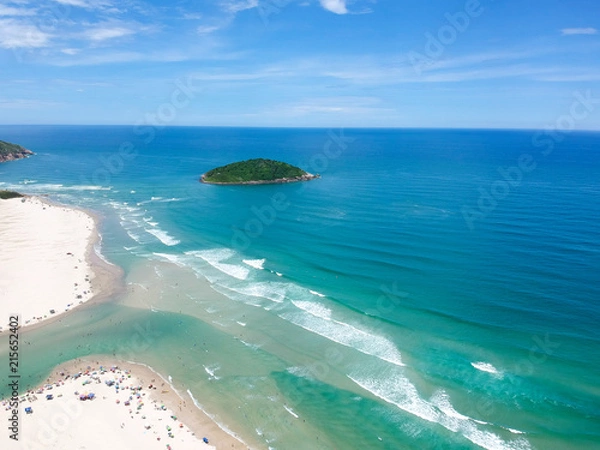 Fototapeta  Aerial view of Brazilian beach with blue sky, white clouds, tourists in the sand, green and blue sea.