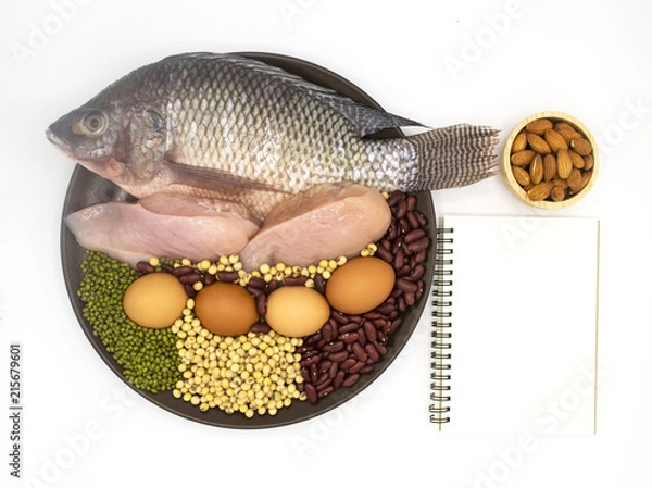 Fototapeta healthy natural food and diet concept - high protein many beans and meat, red beans, green beans, soy beans, egg, chicken and fish in the brown dish on white background with book and pen