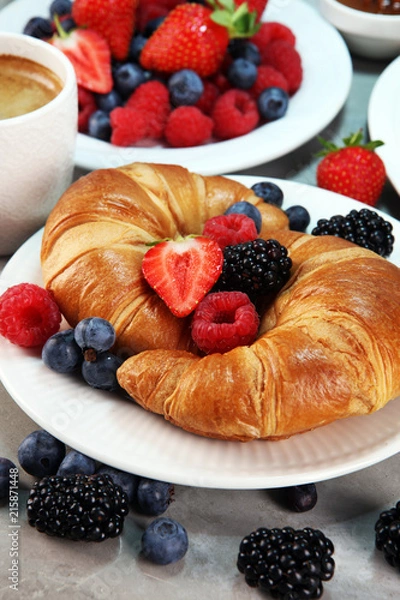 Fototapeta Delicious breakfast with fresh croissants and ripe berries on old marble background.