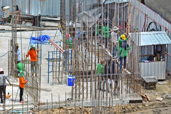 Fototapeta construction worker assembling scaffold stake on building site