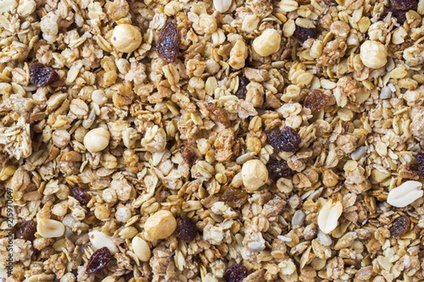 Fototapeta Background of Muesli Breakfast with oat flakes raisins. Close-up view of the crispy granules. The concept of Healthy eating.