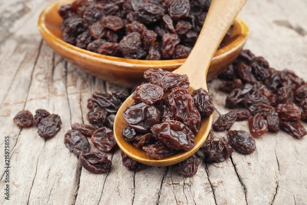 Fototapeta Organic dried Raisins in wood spoon on wooden table, Currant
