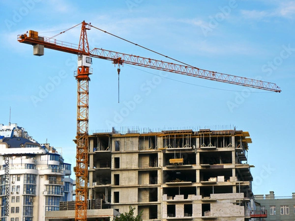 Fototapeta Construction site with crane and building. Crane and building under construction.