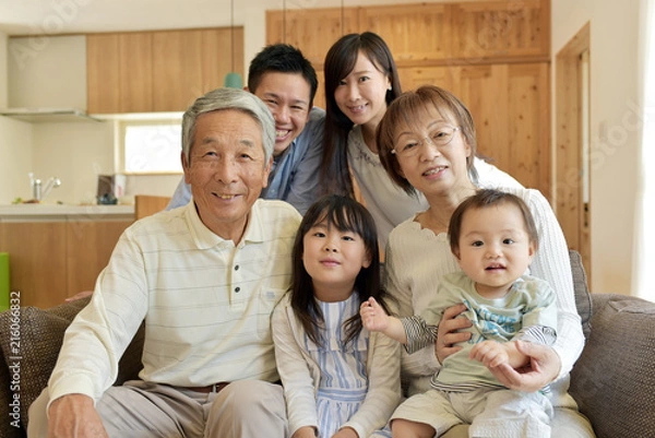 Obraz リビングのソファで微笑む3世代家族