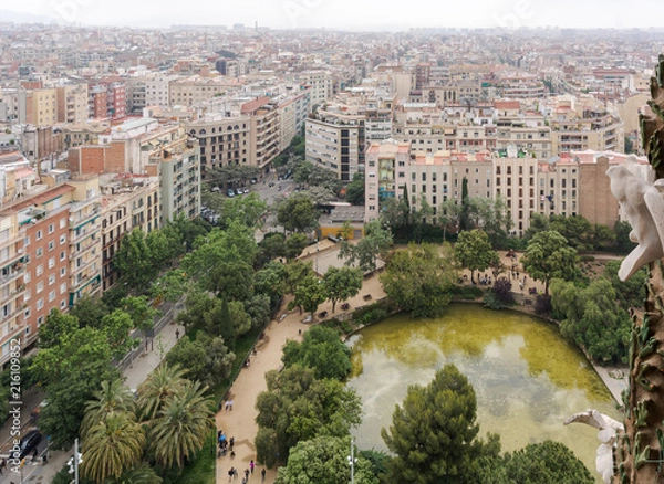Obraz View to Barcelona from the top of the basilica, with the green pond on the Plaza de Gaudi (Gaudi Square) in front of the church and the trees framing it.