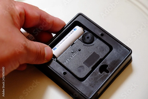 Obraz replacing the battery in a quartz wall clock