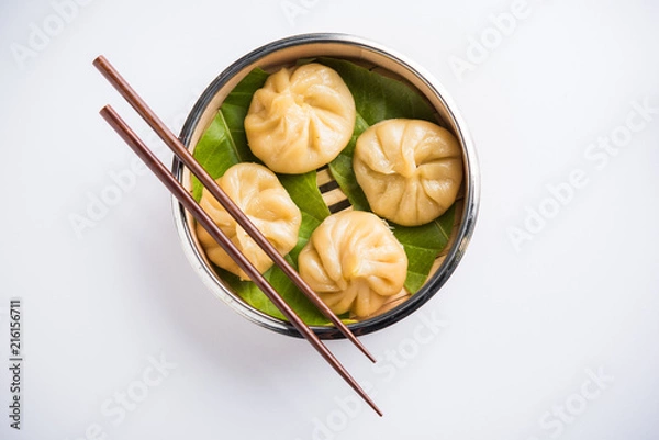Obraz Traditional dumpling momos food from Nepal served with tomato chutney over moody background. Selective focus