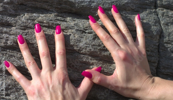 Fototapeta Le mani conle unghie rosse su una roccia