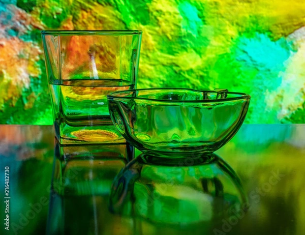 Fototapeta Glass of water with drop and colored background
