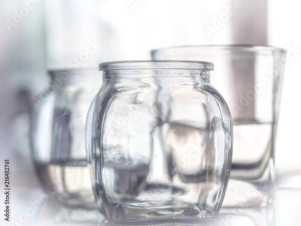 Fototapeta Glass of water with drop and colored background