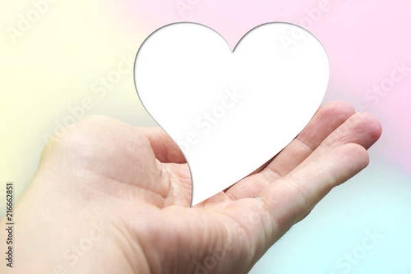 Fototapeta White for text heart shape lay on hand with colorful background. Valentine day. Yellow pink aqua blurred