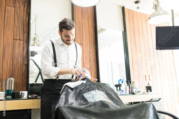 Fototapeta Salon Worker Using Razor To Shave Client's Face