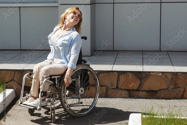 Fototapeta Woman in a wheelchair using a ramp