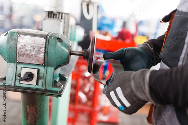 Obraz Metallurgy heavy industry. Factory for production of heavy pellet stoves and boilers. Worker hands close up. Extremely dark conditions and visible noise.