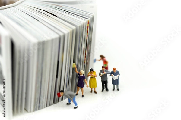 Fototapeta Miniature people: Businessman reading newspaper and sitting on book using as background education or business concept.