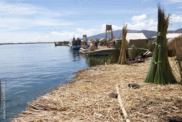 Obraz Landscape of the Uros floating islands in the magic blue colors of the Titicaca Lake with the Andes mountain range in the background.