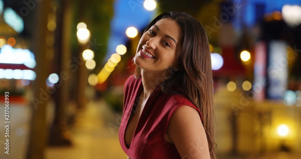 Fototapeta Portrait of cheerful sexy young Latina woman in the city