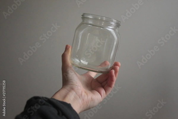 Obraz a hand holding an empty glass bottle