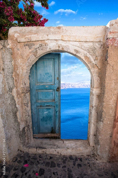 Fototapeta Eine alte Tür in Santorini mit einer schönen Ansicht  auf das Meer
