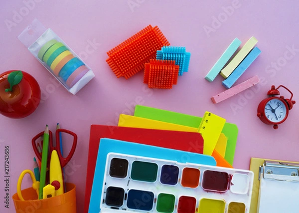 Obraz The schoolboy's accessories lie on a pink table. Textbooks and office.
