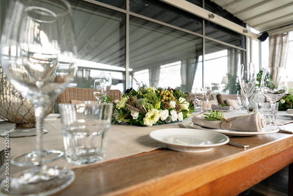 Fototapeta Wedding Banquet or gala dinner. The chairs and table for guests, served with cutlery and crockery. Covered with a linen tablecloth runner. party on terrace