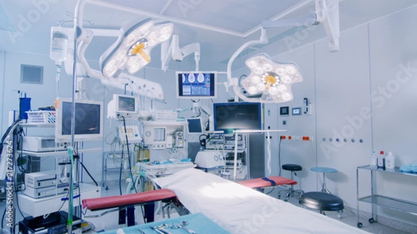 Obraz Ujęcie zaawansowanej technologicznie sali operacyjnej bez ludzi, gotowej do operacji. Prawdziwa nowoczesna sala operacyjna ze sprzętem roboczym, oświetleniem i komputerami gotowymi dla chirurgów