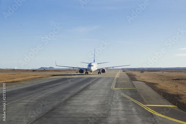 Obraz White passanger plane on runway air strip while takeing off take off in iceland keflavik northern country clear sky