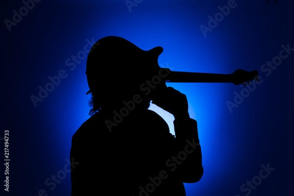 Obraz Shadow of a musician carrying a guitar