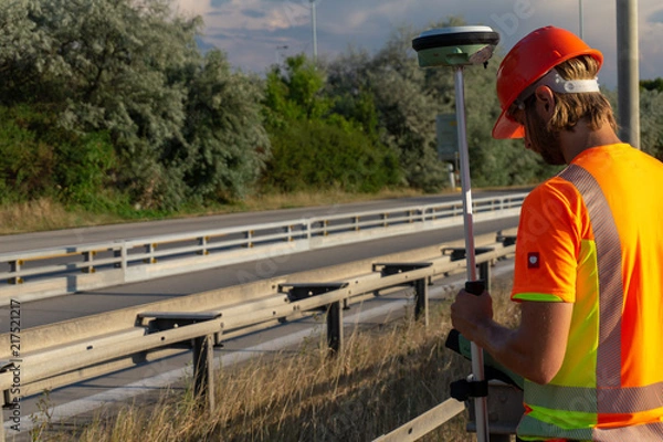 Fototapeta Surveyor with GPS on construction site during the sunny day