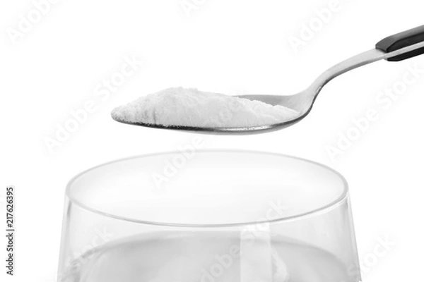 Obraz Spoon with baking soda over glass of water on white background
