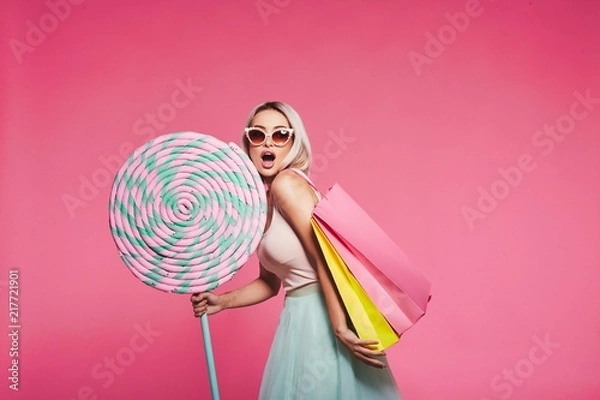 Fototapeta Śliczny model ze słodyczami i torbami na zakupy