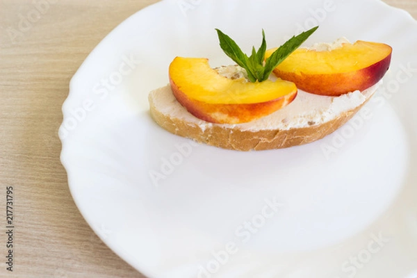 Obraz Sandwich with cream cheese and nectarines. Fruit sandwich on a white plate.