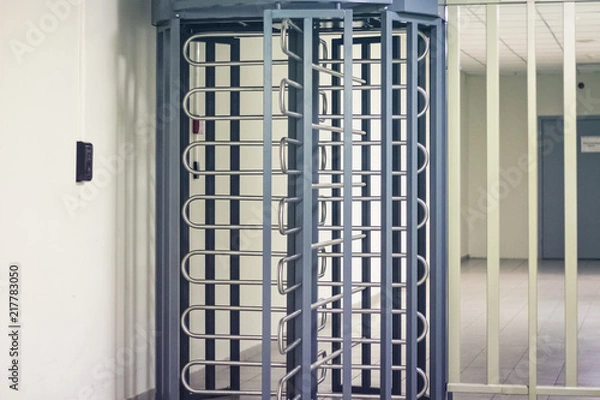 Obraz Wejście przez duże stalowe kołowroty w całości wykonane przez ludzi. Koncepcja bezpieczeństwa z przepustką elektroniczną