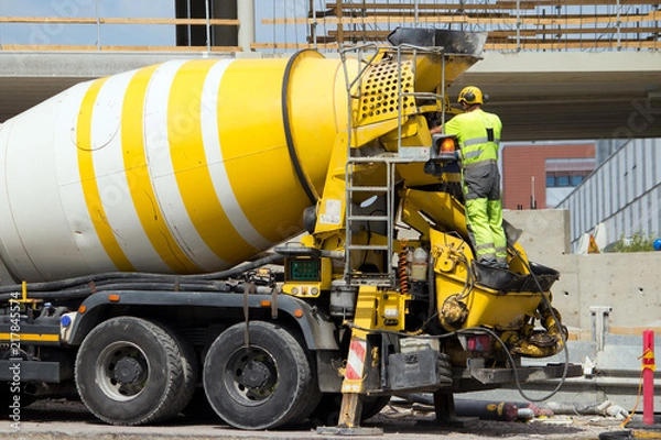 Obraz Construction site worker washing concrete truck