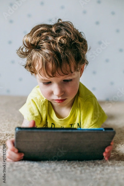Obraz Toddler boy staring at tablet. Education, gadget, dependency, technology, addiction, child eyesight, raising children concept