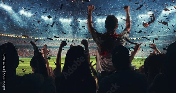 Obraz Fans celebrating the success of their favorite sports team on the stands of the professional stadium while it's snowing