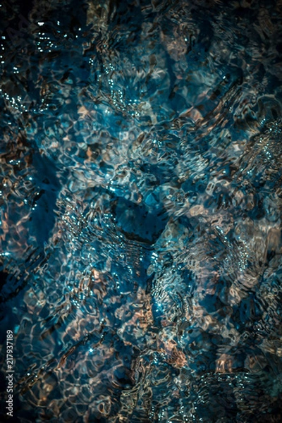 Fototapeta Crystal clear blue water in a mountain stream. A photo from the top of the detail. Top view.