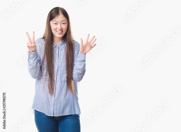 Fototapeta Young Chinese woman over isolated background showing and pointing up with fingers number seven while smiling confident and happy.