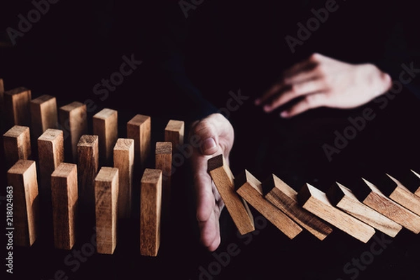 Fototapeta Business risk control concept, Businessman protect wooden block fall to planning and strategy in risk to business Alternative and prevent. Investment Insurance Business.