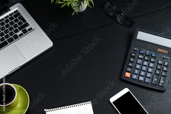 Fototapeta Top view, black desk with computer graph, magnifier and calculator