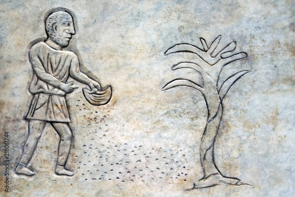 Fototapeta Bas-relief of an ancient Roman farmer throwing seeds on the ground. In the the public Baths of Diocletian in Rome, Italy. It was built from 298 to 306
