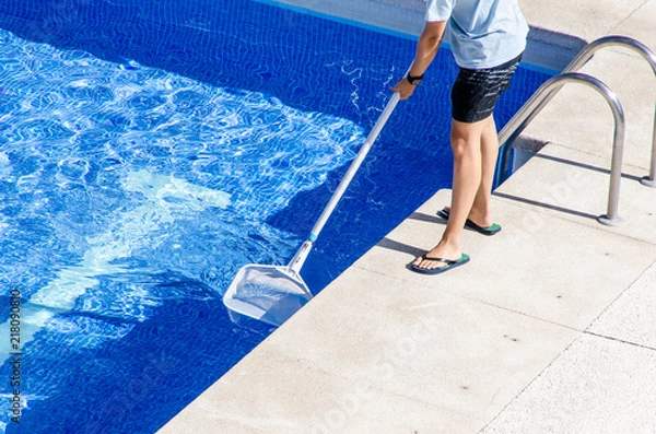 Obraz cleaning the swimming pool with a net