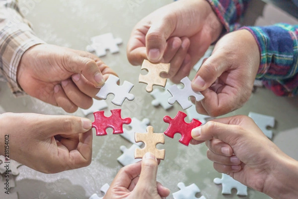 Obraz Closeup of businessman and woman with jigsaw puzzle pieces,strategy concept.
