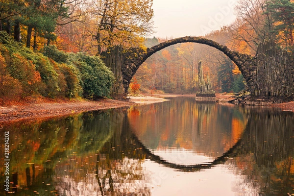 Fototapeta Most Rakotza (Rakotzbrücke, diabelski most) w Kromlau, Saksonia, Niemcy. Kolorowa jesień, odbicie mostu w wodzie tworzy pełne koło. Niezwykłe i ciekawe miejsca w Niemczech.