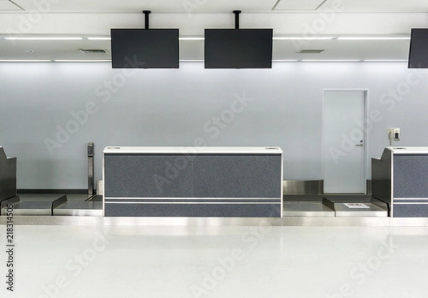 Fototapeta Empty desk in international airport at check-in counter with loading baggage area on background.