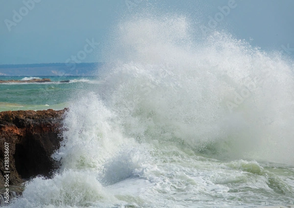 Fototapeta White ocean waves crashing to rocks