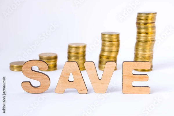 Fototapeta Word save of three-dimensional letters is in foreground with growth columns of coins on blurred background. Save concept for finance, economics, money, banks, business, startup, investing, markets
