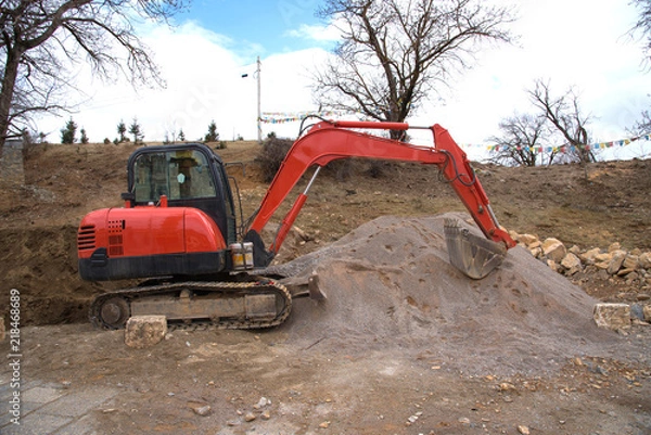 Fototapeta View of backhoe was digging a pit in the ground for rainwater,Crawler excavator truck ,Construction digger machine in flat. Backhoe loader, Heavy equipment. Backhoe working at construction side.