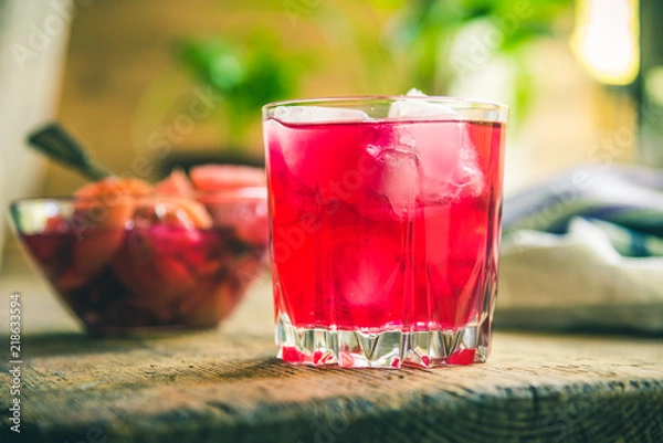 Obraz Red fruit drink with ice on a rustic background