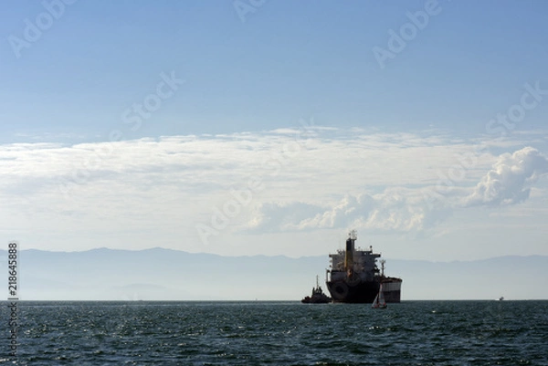 Obraz Oil tanker in backlight coming out of port